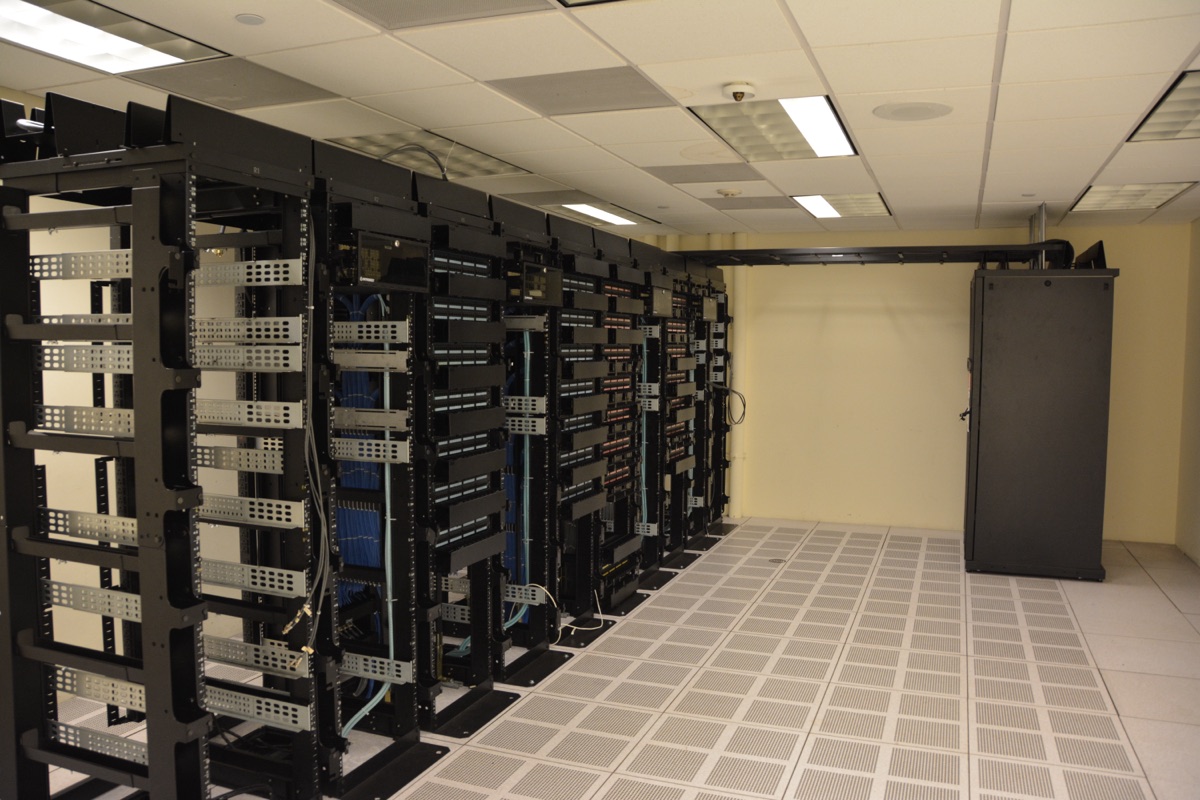 Rows of server racks inside a large AI data center — the same class of facility Fluidstack operates